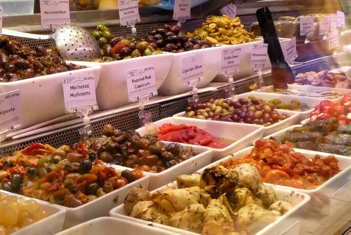 Selection of antipasto on display, including olives and artichoke hearts.