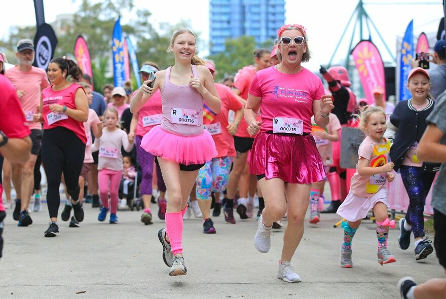 Two runners participating in the Mother's Day Classic fun run, wearing pink tutus and sunglasses.