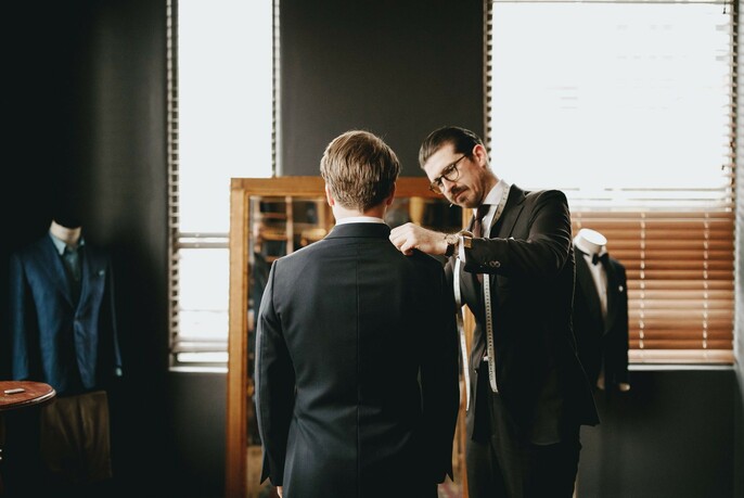 Man having suit measurements taken by a tailor.