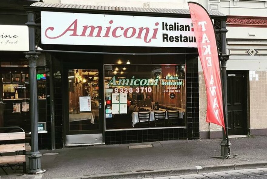 The shopfront of Amiconi Italian Restaurant with the restaurant name in red on a white signboard.