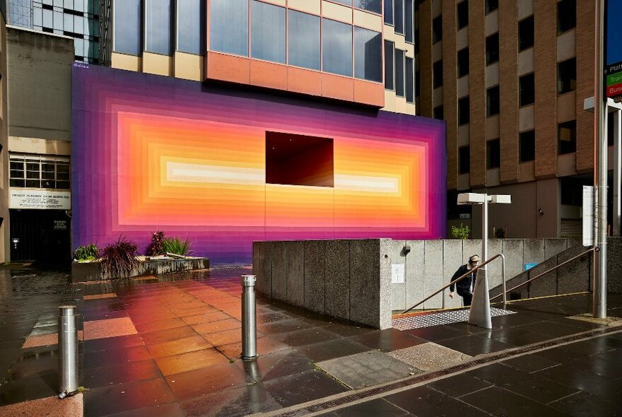 Exterior wall of a city office building painted in a spectrum of colours including purple,orange and yellow.