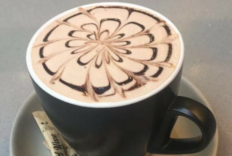 Close up of patterned cup of coffee.