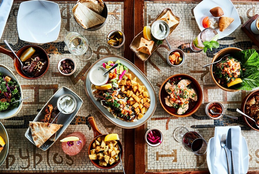 Aerial view of a table filled with an abundance of dishes and wine.