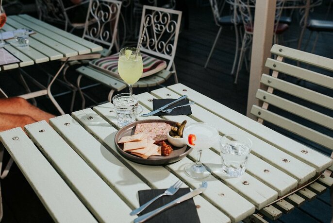 Picnic table with drinks and food on the deck.