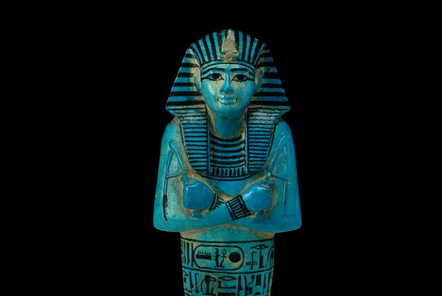 Upper half of a human-shaped tomb, Egyptian, blue with black painted markings and decorations, approx 1200 BC.