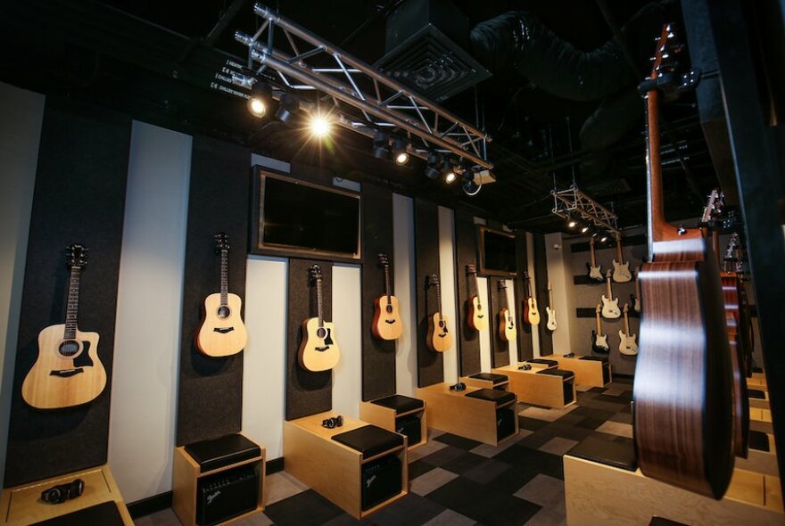 A sophisticated music store with guitars hanging on the wall. 
