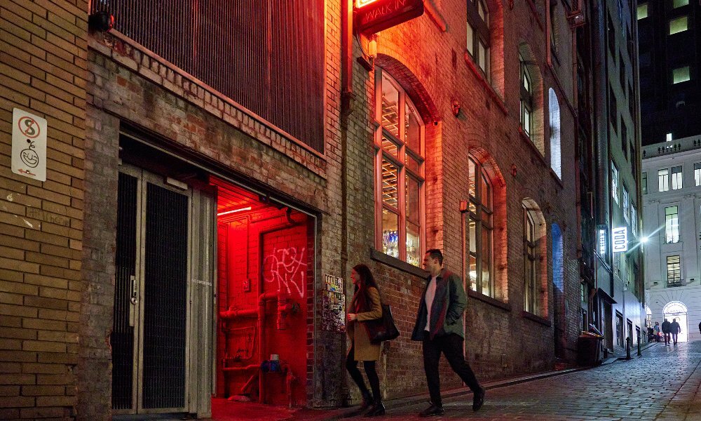 A couple are walking into a restaurant in a hidden laneway 