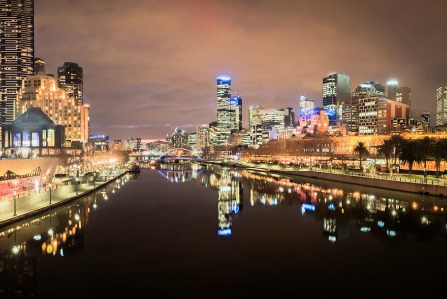 Yarra River at night with the illuminated banks of Southbank Promenade on the left and Northbank on the right.