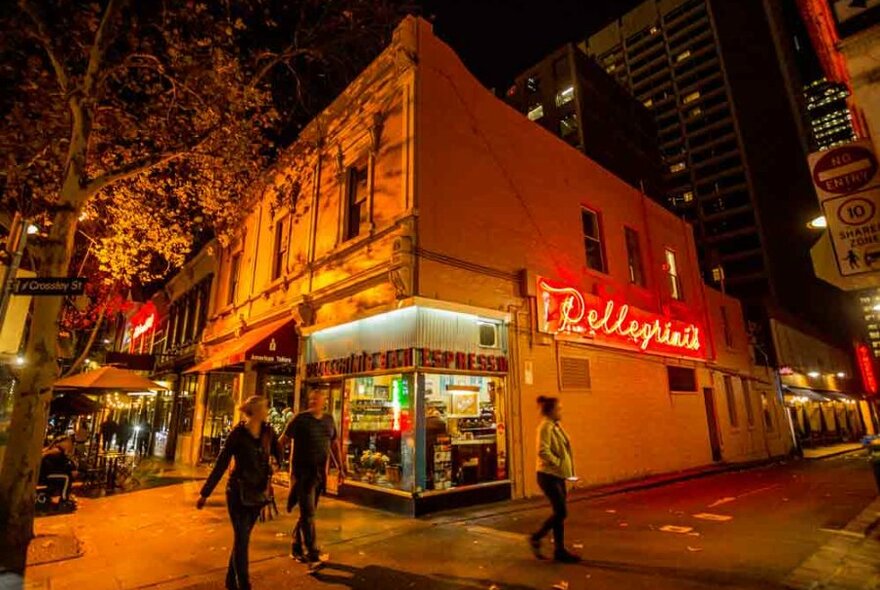 People walking outside a cafe at night