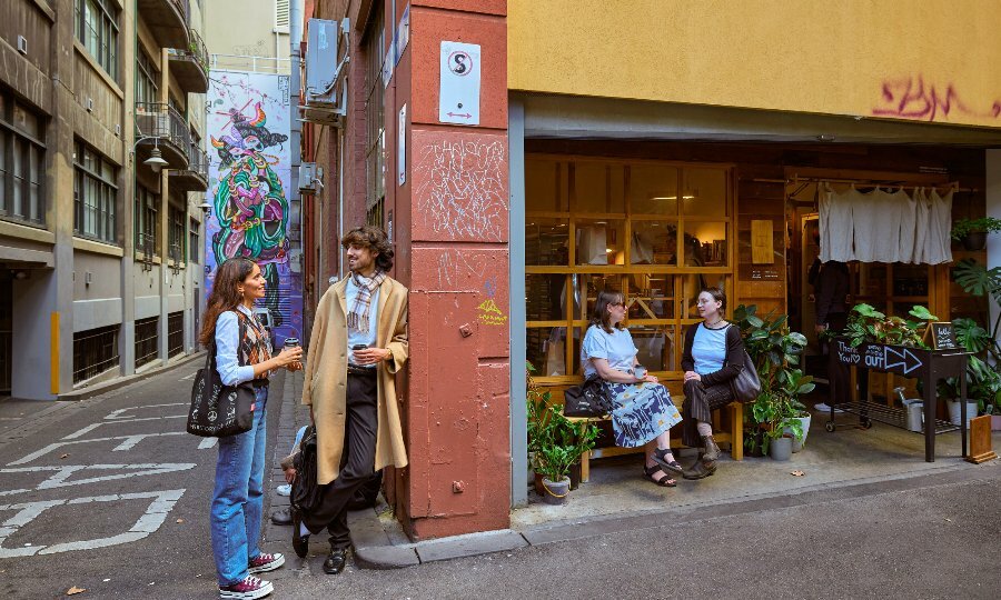 Four people are standing outside a laneway cafe