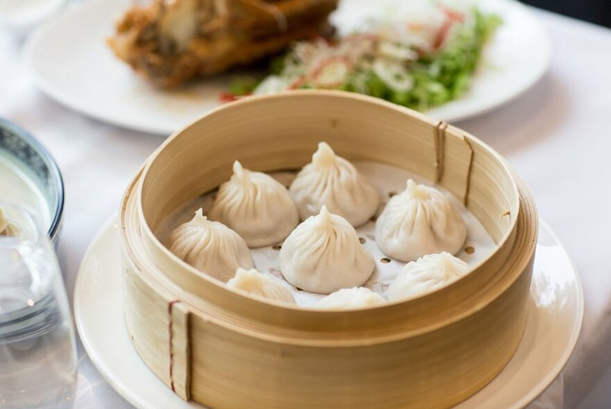 A bamboo basket filled with steamed dumplings.