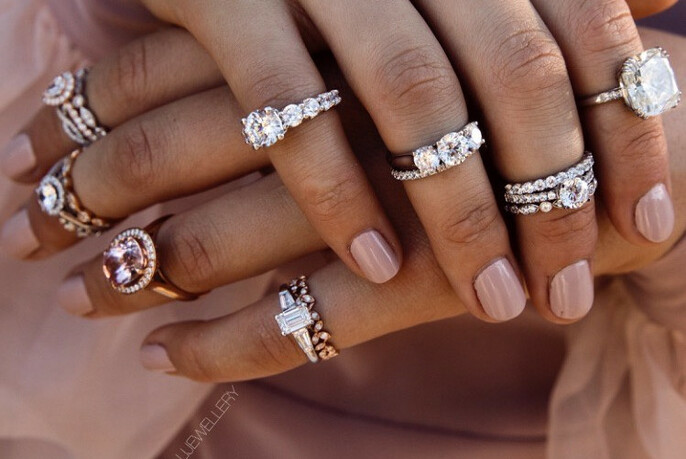 Pair of hands displaying diamond rings on each finger.