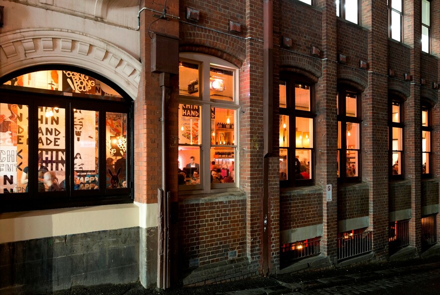 View of the outside of the restaurant at night showing an old red brick building.