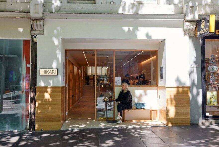 A woman sitting in the window of a cafe