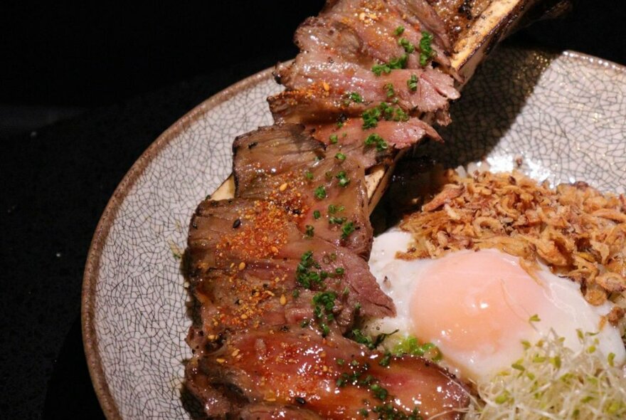 A Japanese beef dish with an egg in the centre and dried onions. 