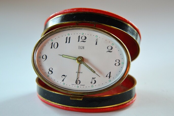 Pop-up travelling clock in red and black case.
