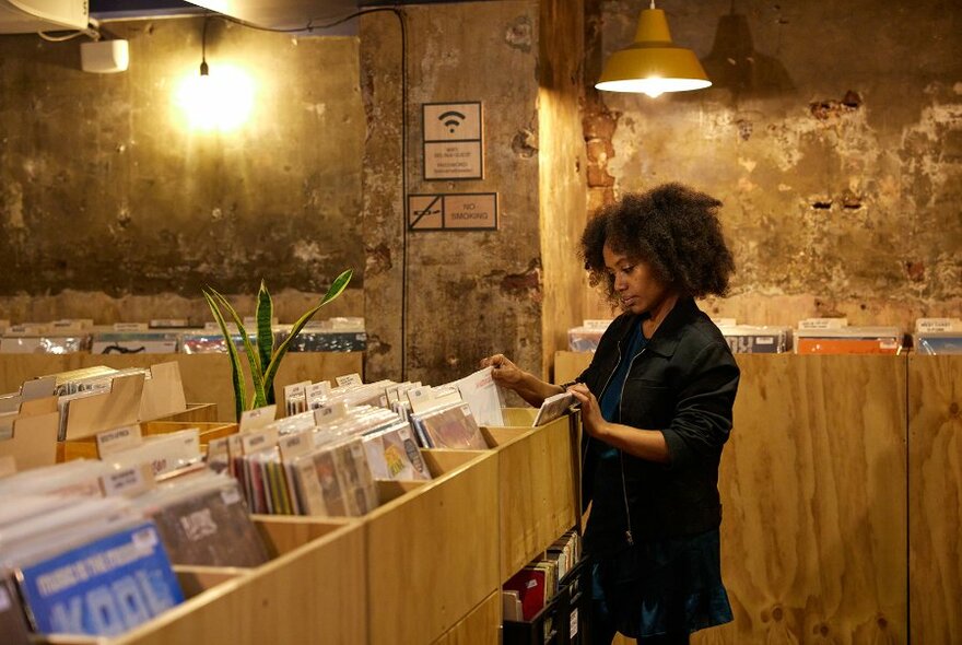 A woman flicking through records in a shop.