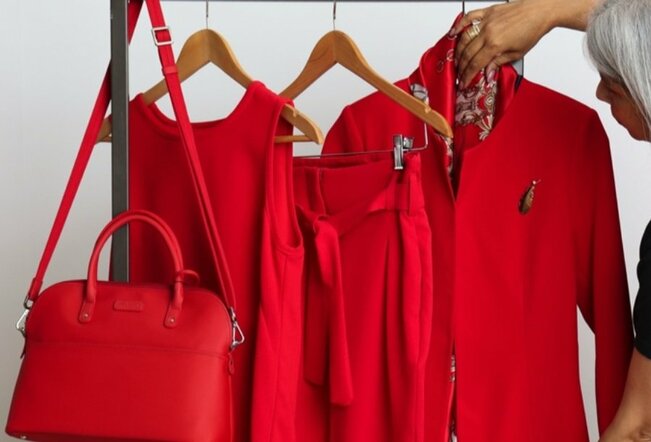 Red jacket, bag and dress on hangers.