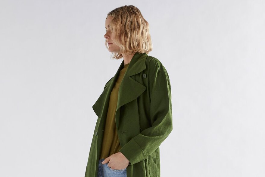 A model posing in a green linen trench.