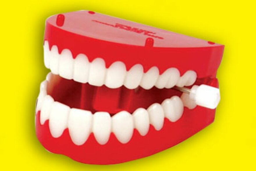 Novelty wind-up teeth against a yellow background.