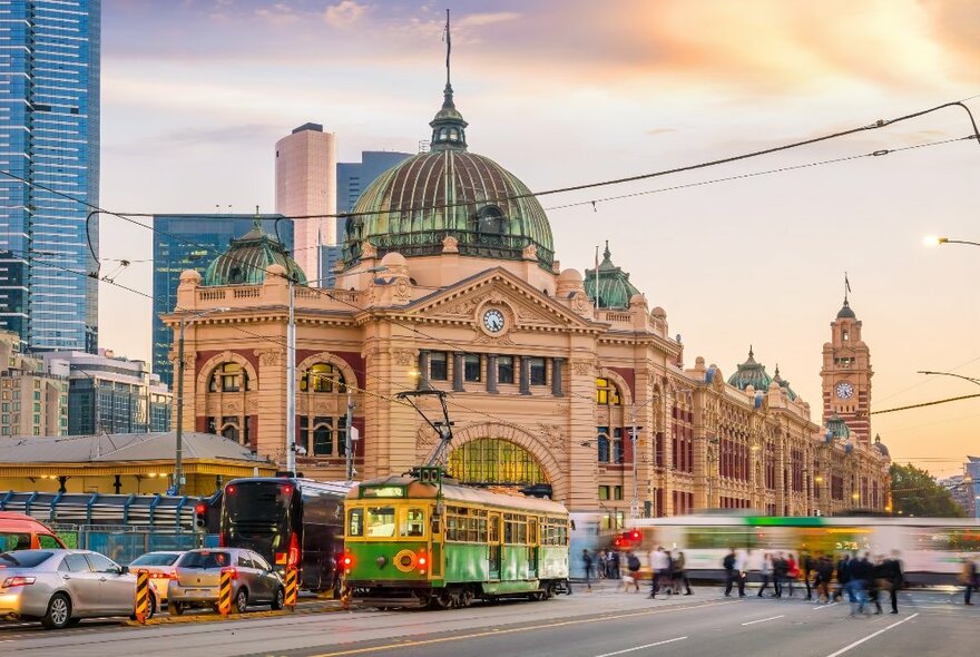 Flinders Street Station in Melbourne with traffic and trams passing.