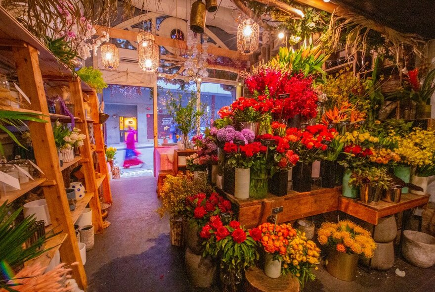 A florist shop with lots of colourful flowers and glowing lights.