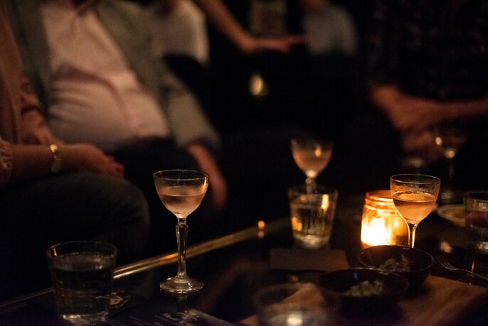 Small glasses of alcohol in a candle-lit bar.