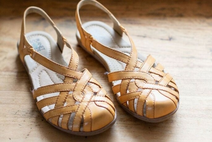 A pair of ladies light brown woven leather sandals.