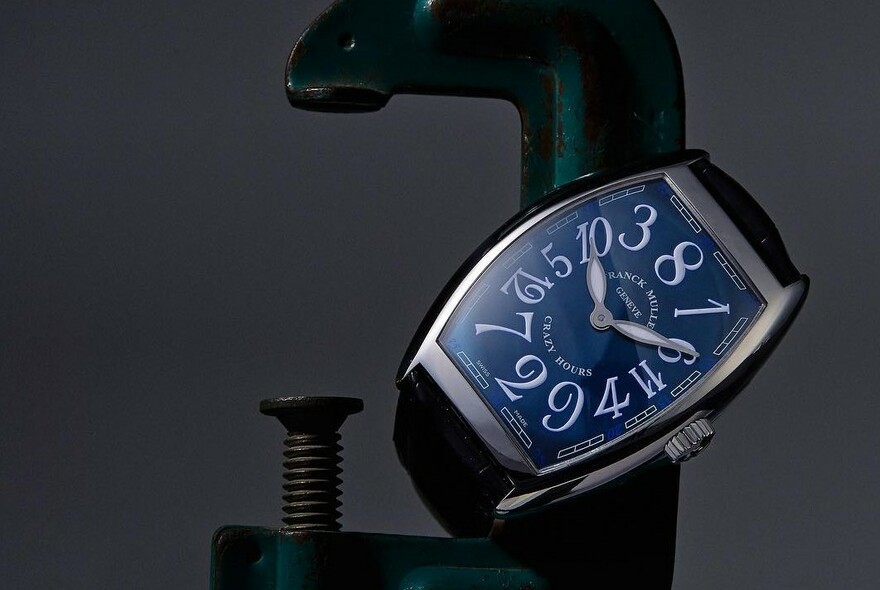 Wristwatch with elongated blue face and white numerals.