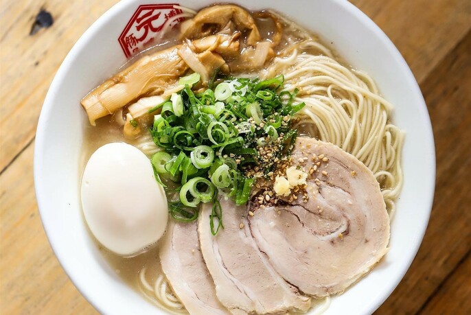 White bowl of meat, noodles and egg.