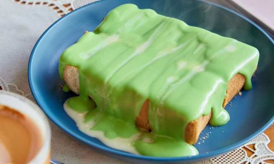 A piece of white toast with green jam on it