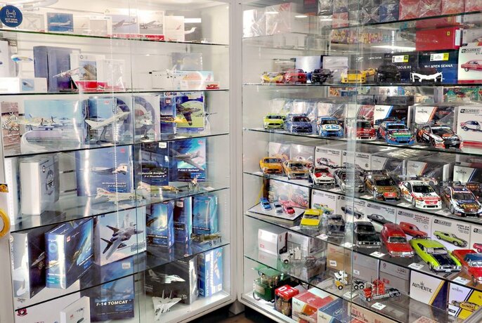 Glass shelves lined with car and plane hobby sets.