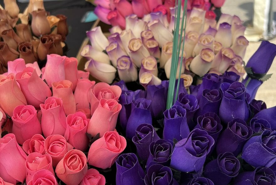 Bunches of different coloured roses at a market. 