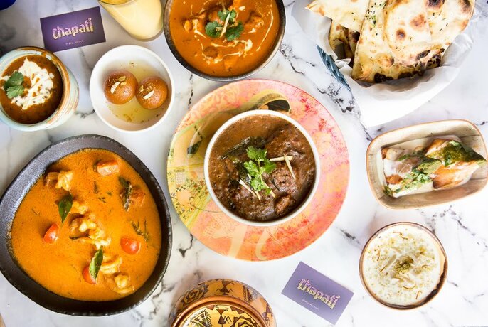 Bird's-eye view of table full of Indian dishes.