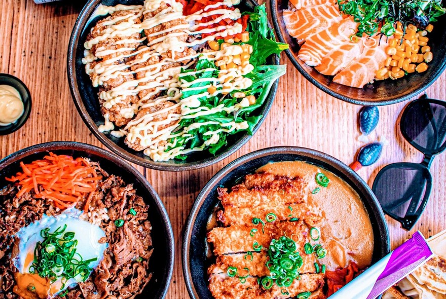 Bird's-eye view of a number of bowls of Asian food.