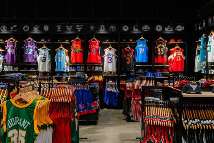 Wall and floor shelves of colourful NBA jerseys. 