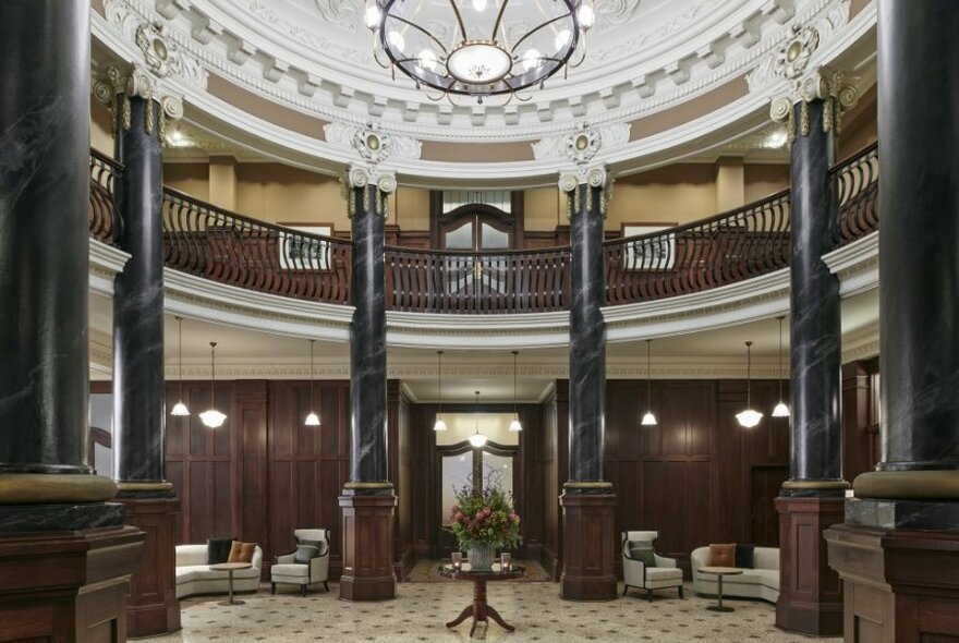 A hotel lobby with high ceilings, columns and a chandelier.