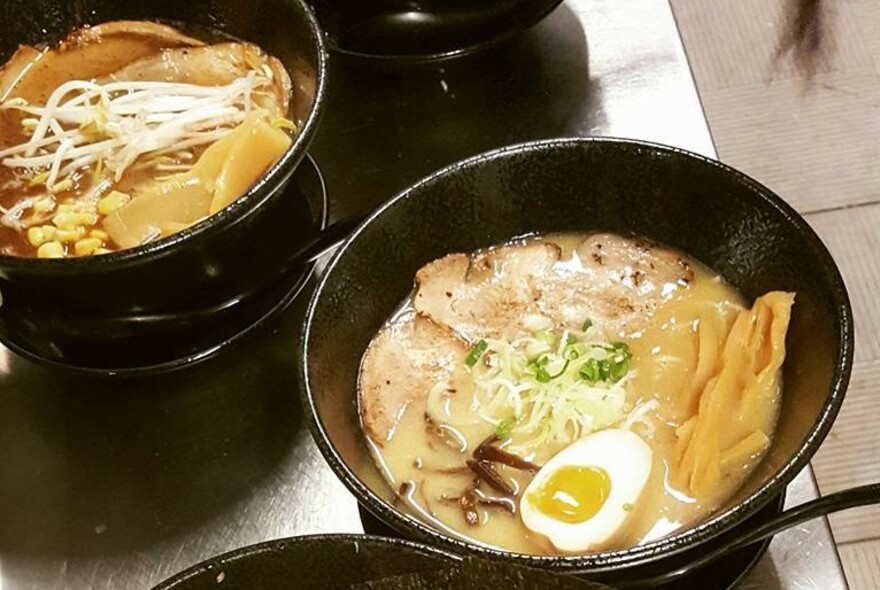 Two bowls of ramen on a table top.