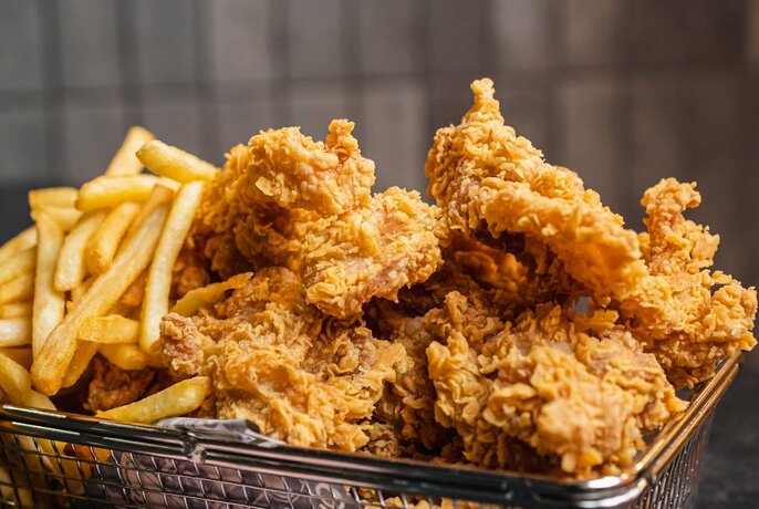 A basket filled with Korean fried chicken and chips.
