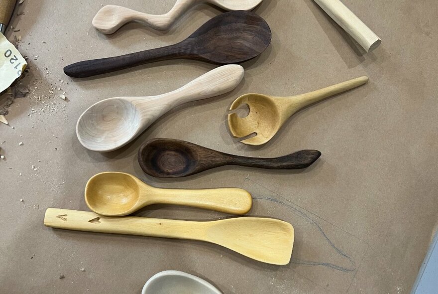 A selection of carved timber spoons on a table.