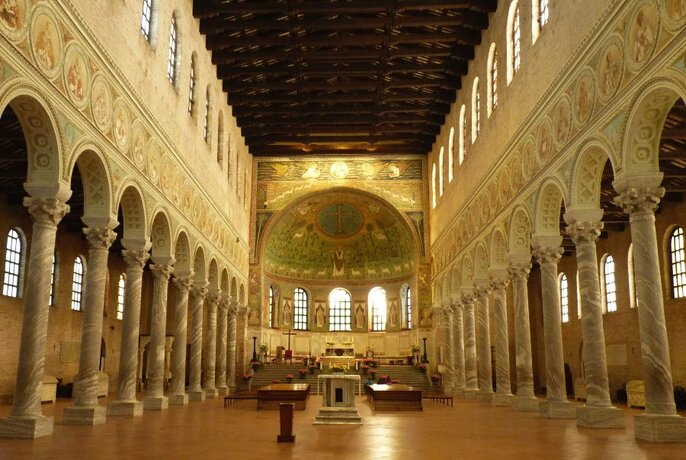 Interior of a Byzantine church in Ravenna, with arched porticoes and apse.