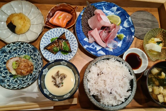 Dishes including rice, soup and meat in Japanese crockery.