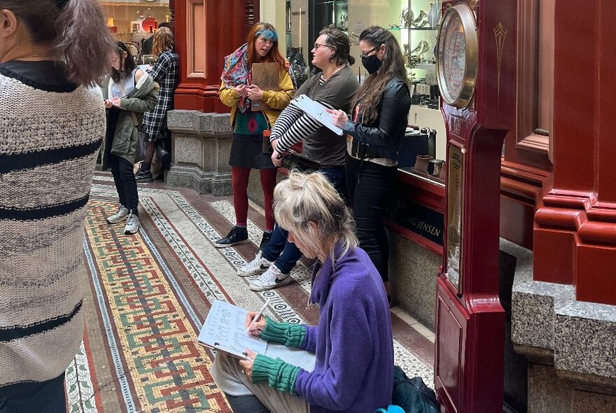 People drawing sketches in a Melbourne arcade.