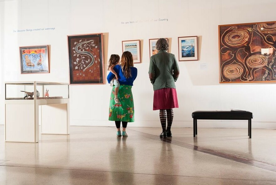 People looking at Aboriginal art inside the Koorie Heritage Trust.