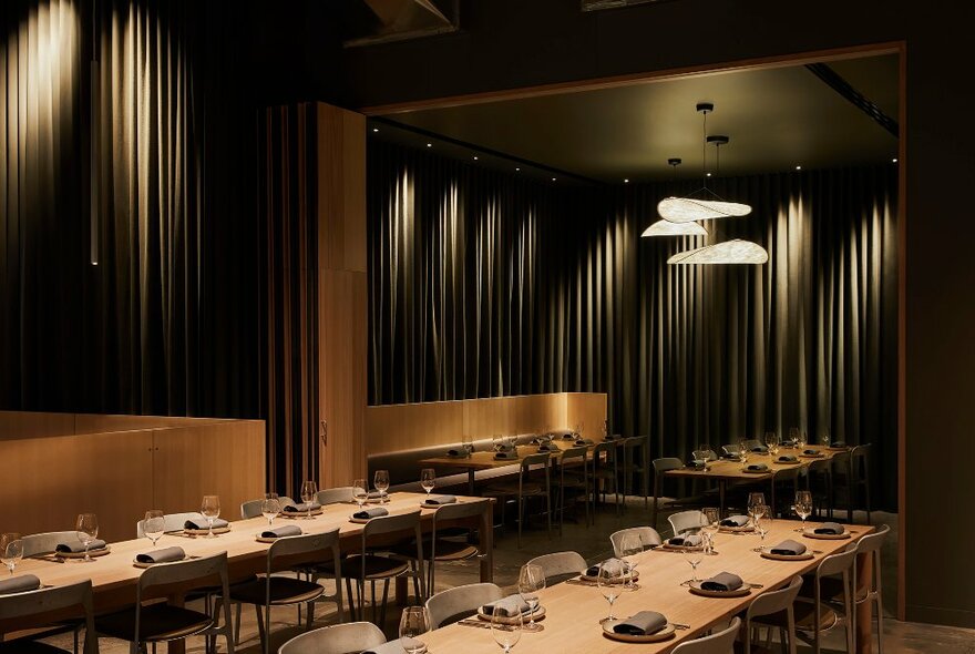 A dimly-lit restaurant space set for guests.