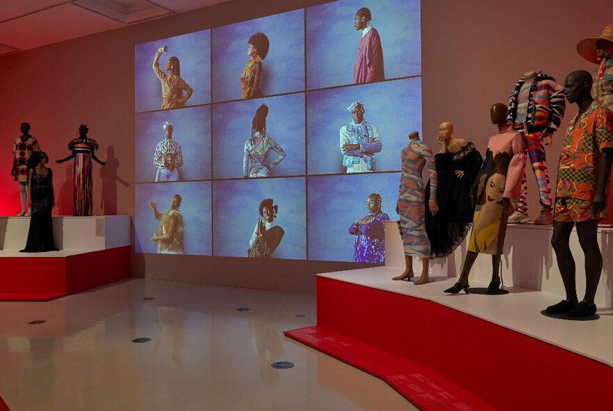 A display of mannequins wearing different outfits in a gallery setting.