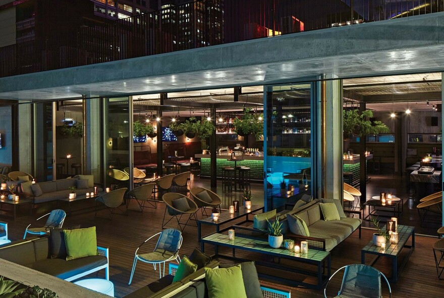 Outdoor seating of the Rooftop at QT bar at night.