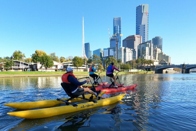 One yellow and one red water bike on Yarra, cityscape at rear.