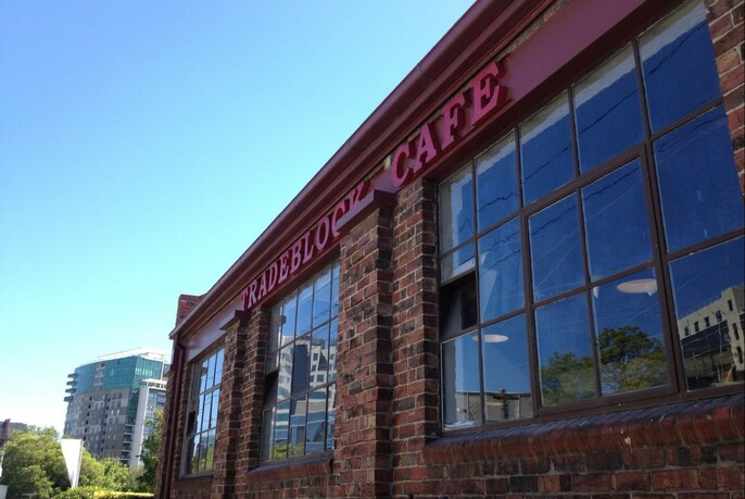 Tradeblock Cafe red brick building with large windows.