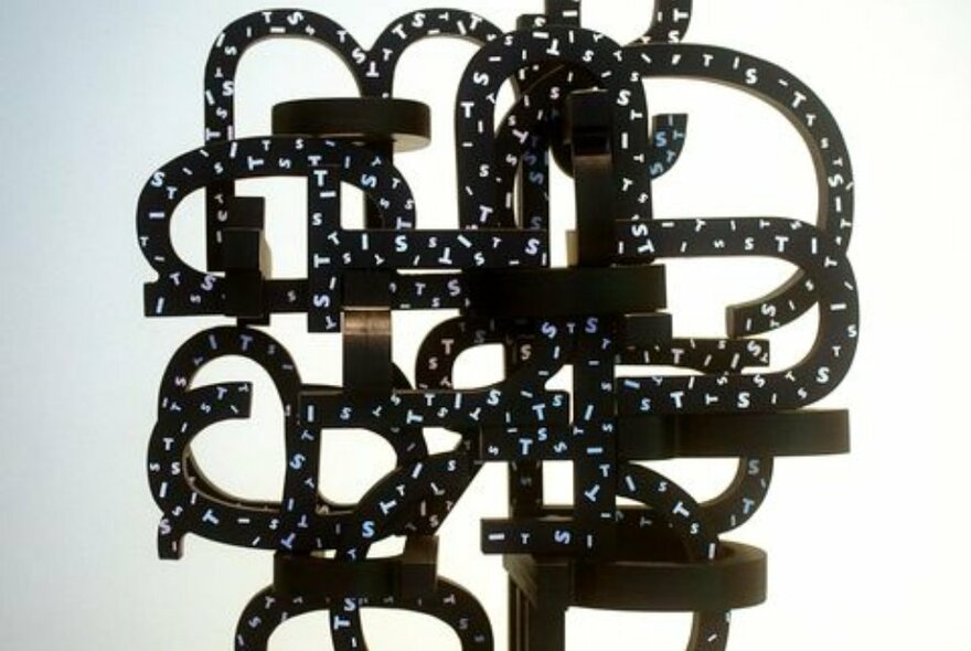 An abstract sculptural artwork consisting of black curled shapes.